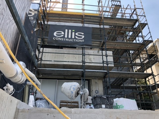A building surrounded with scaffolding, showing an 'Ellis Constructions' banner